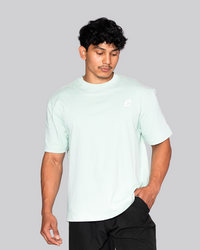 A man dressed in a mint-green shirt that reads "gymryu club," emphasizing strength and performance for dedicated athletes.