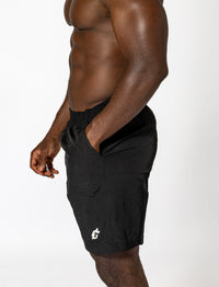 A man wearing black shorts, showcasing durable, moisture-wicking gym wear designed for optimal performance.