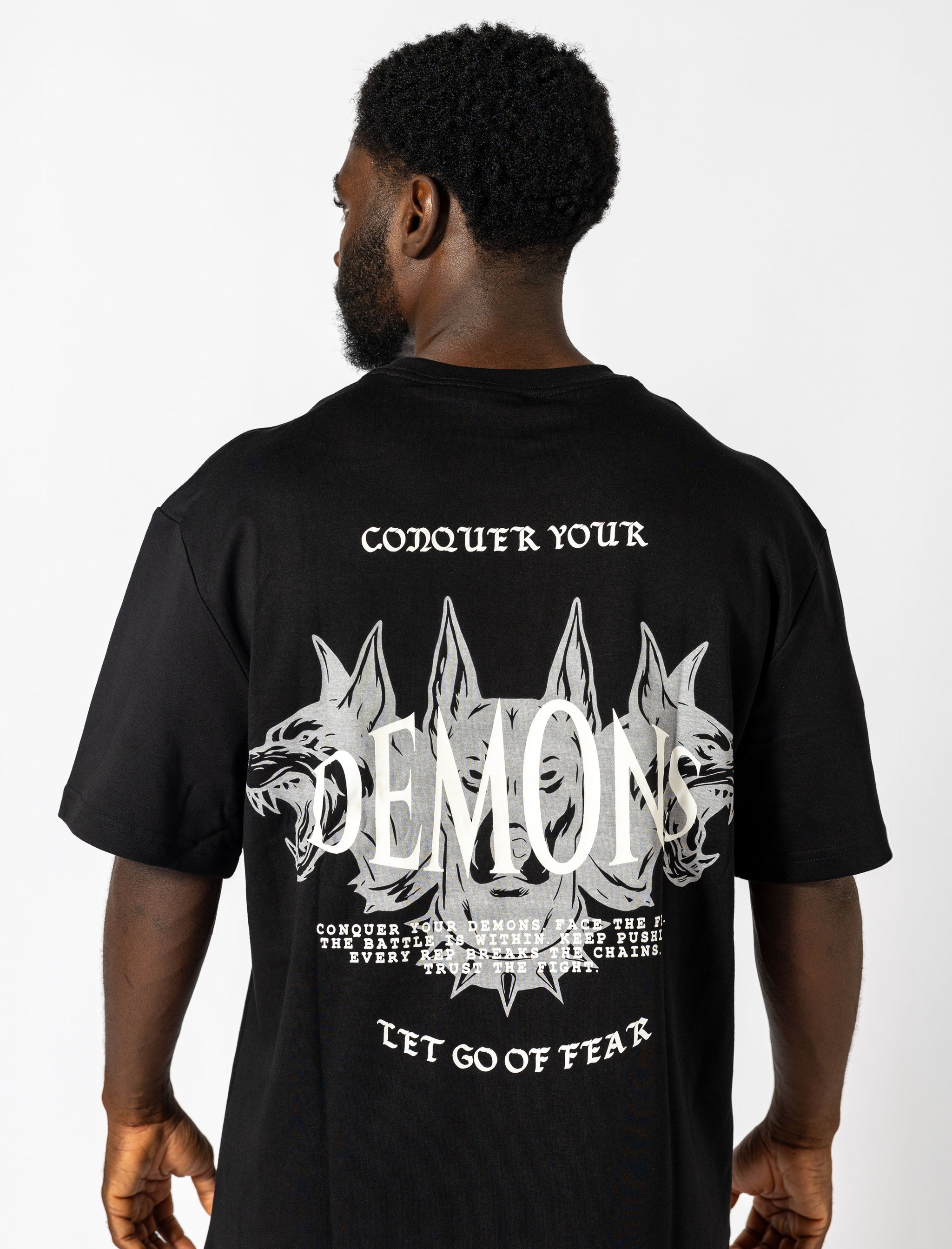  Oversized black tee with white lettering "Conquer Your Demons," perfect for training, layering, or relaxed casual outings.
