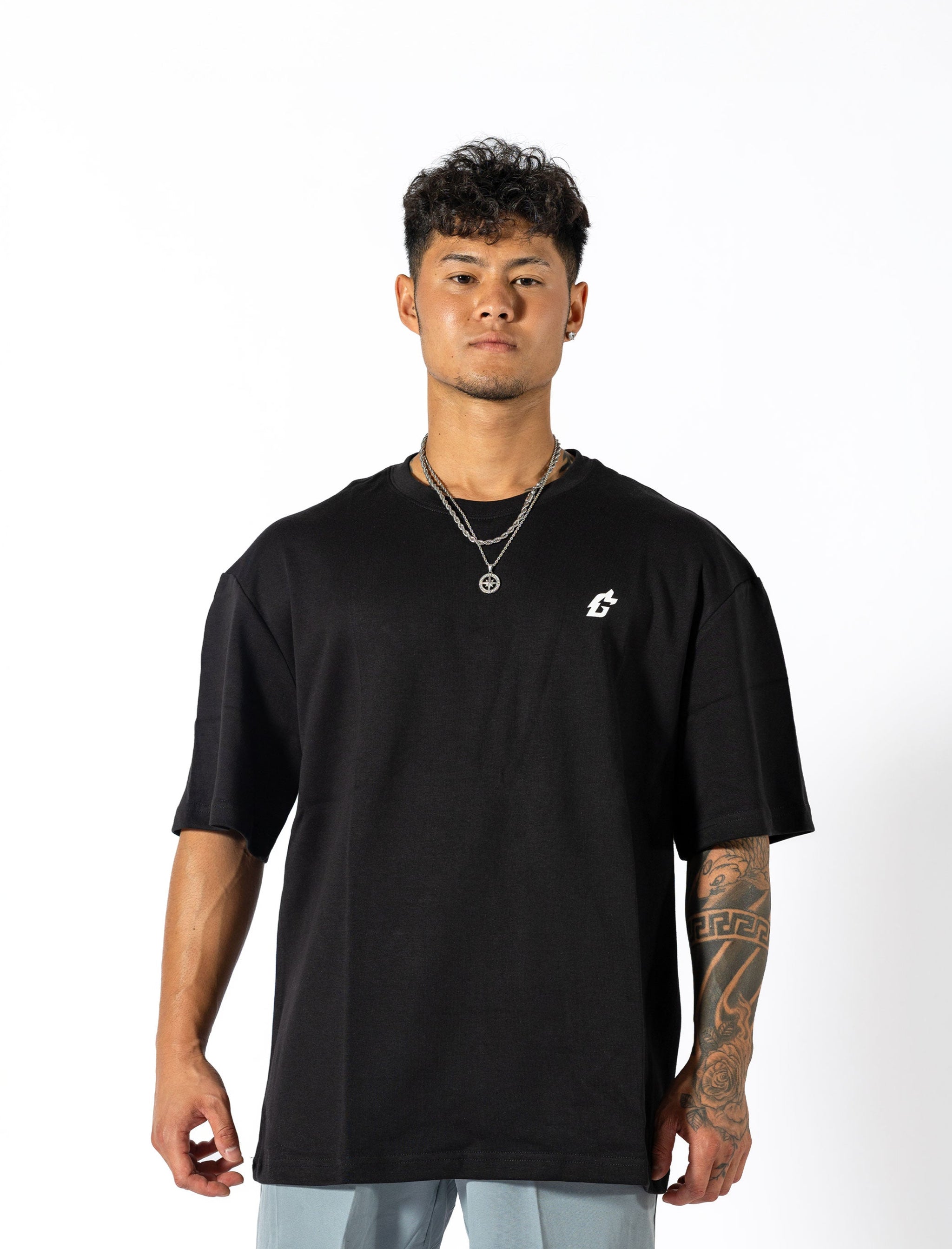 A man dressed in a black shirt that reads "gymryu club," emphasizing strength and performance for dedicated athletes.