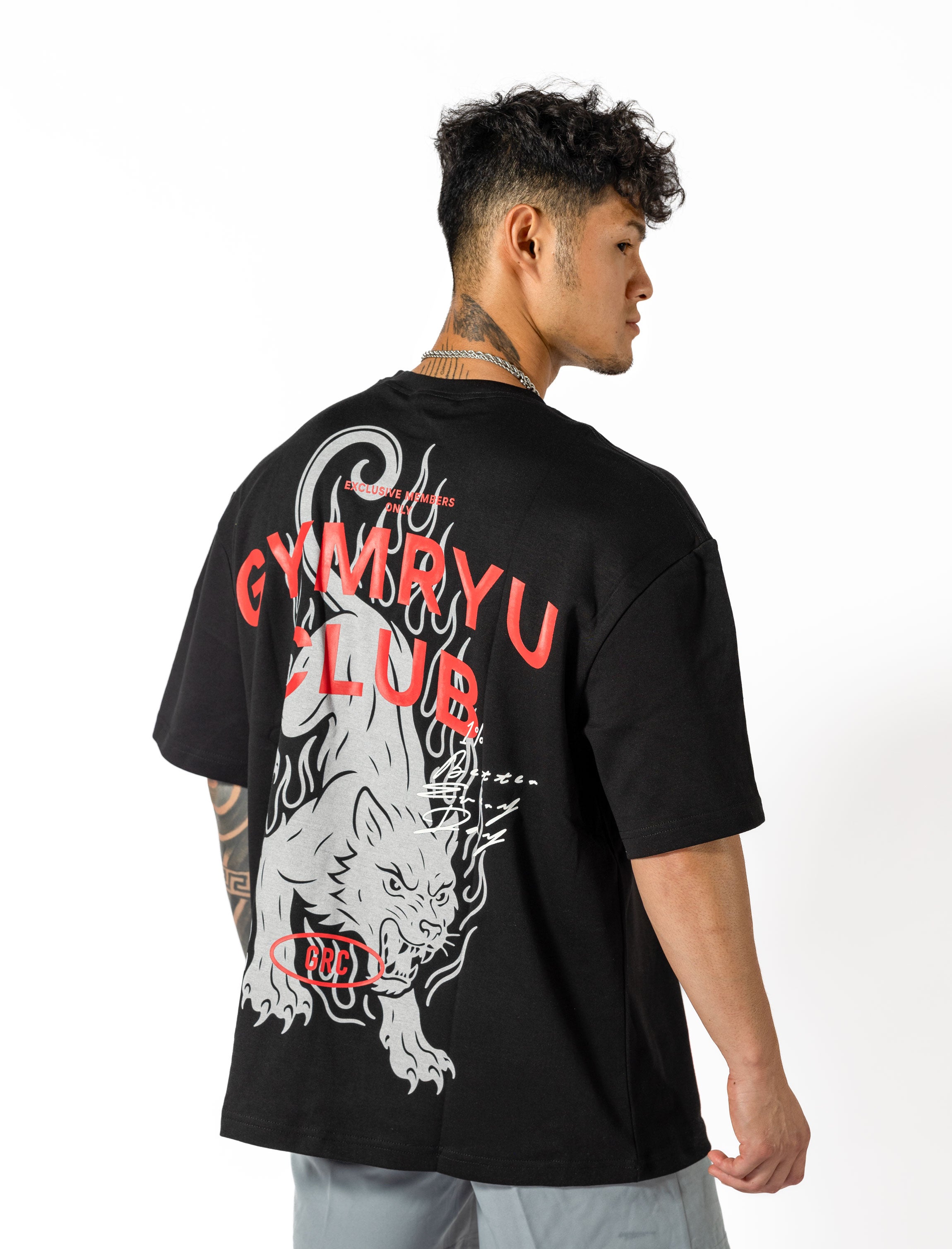 A man dressed in a black shirt that reads "gymryu club," emphasizing strength and performance for dedicated athletes.