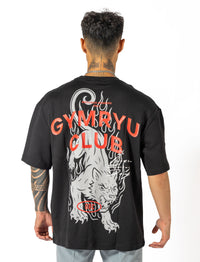 A man dressed in a black shirt that reads "gymryu club," emphasizing strength and performance for dedicated athletes.