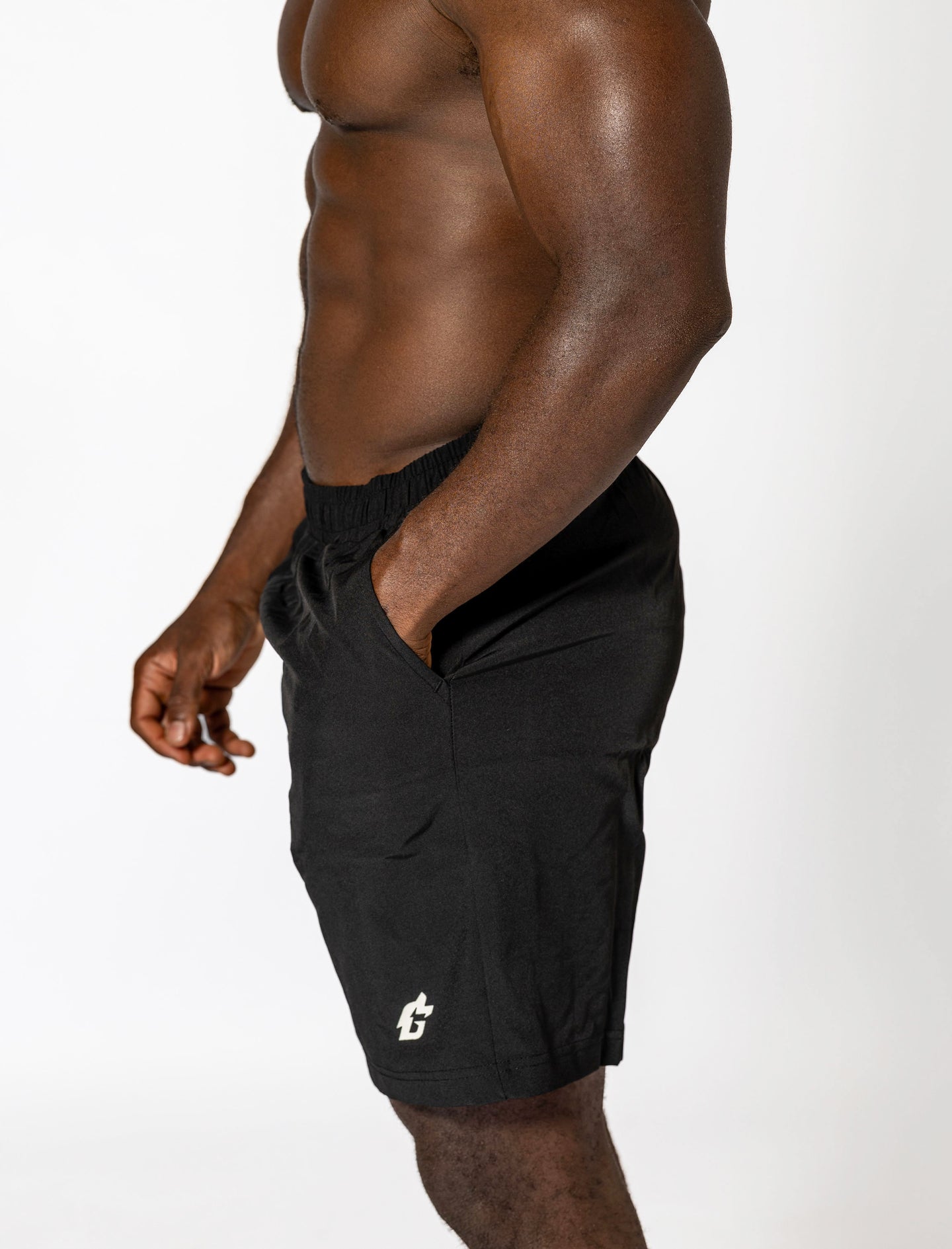 A man wearing black shorts, showcasing durable, moisture-wicking gym wear designed for optimal performance.