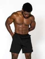 A man in black shorts, featuring a streamlined cut and secure pockets for comfort during workouts.