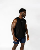 A man in a black tank top and blue shorts, demonstrating a stylish athletic look ideal for lifting and all-day wear.