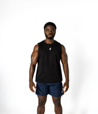 A man in a black tank top and blue shorts, embodying strength and style, prepared for intense lifting sessions.