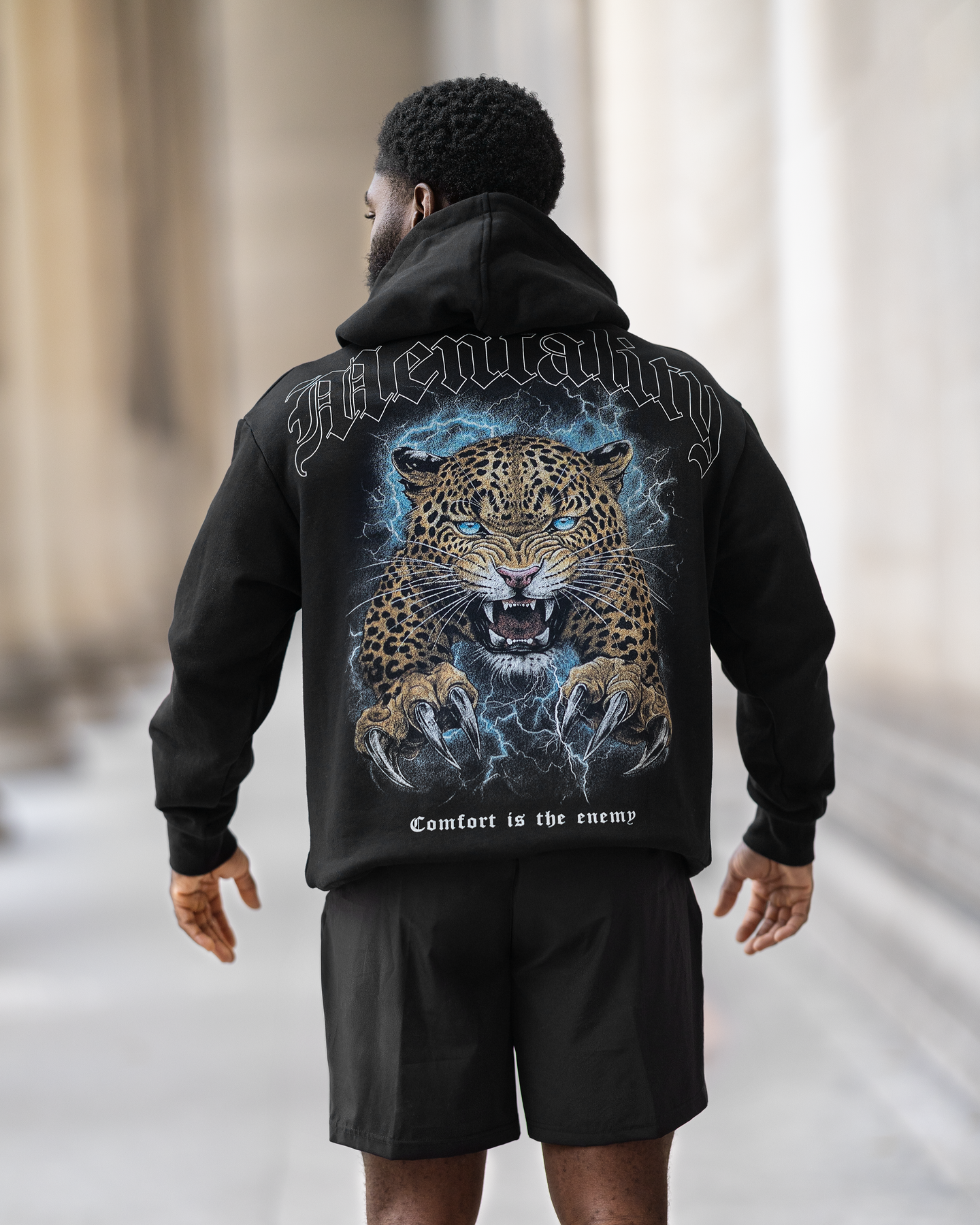 A man in a black hoodie featuring a leopard print, showcasing a stylish and relaxed fit designed for winter activities.